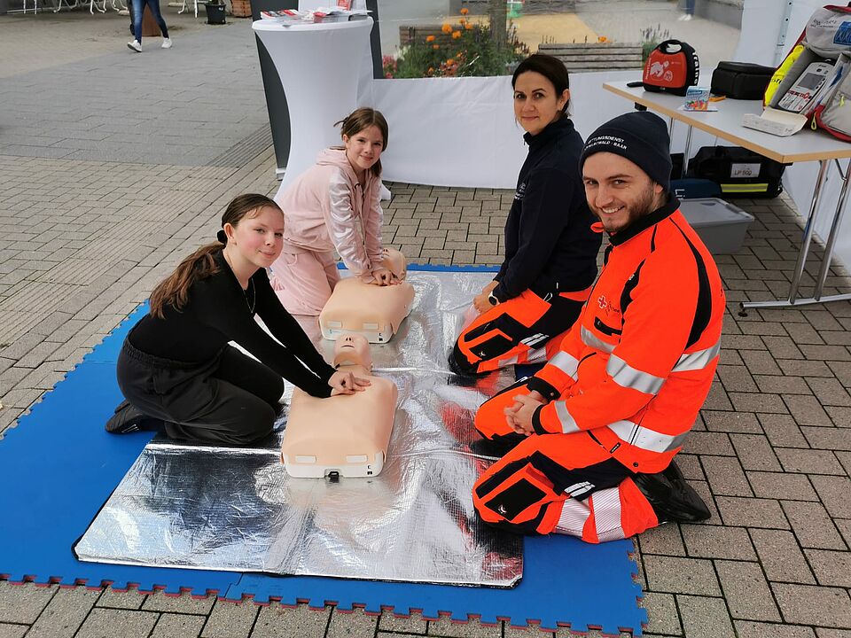 Kinder üben Reanimation an einer Puppe